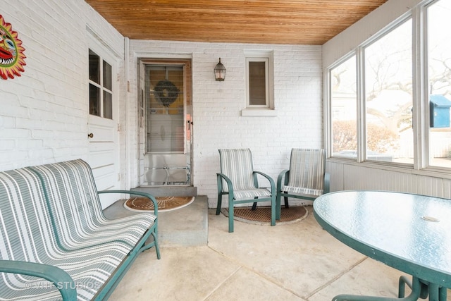 sunroom with plenty of natural light and wood ceiling