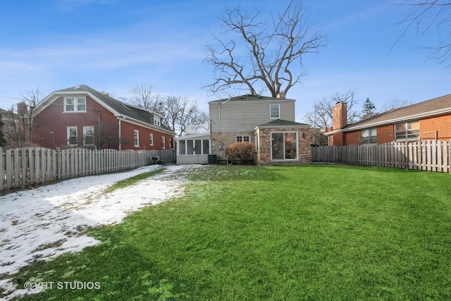 rear view of house featuring a sunroom and a yard