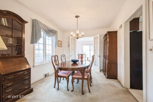 dining space with light colored carpet, crown molding, and an inviting chandelier