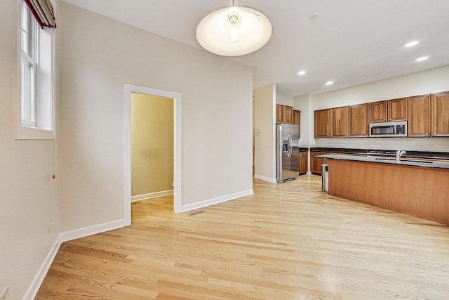 kitchen featuring appliances with stainless steel finishes and light hardwood / wood-style flooring