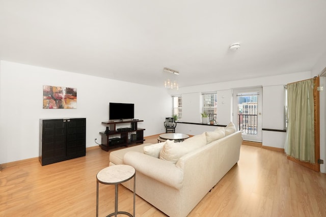 living room featuring light hardwood / wood-style floors and a notable chandelier