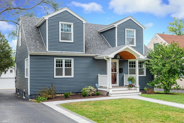 view of front of home featuring a front lawn, an outdoor structure, and a garage