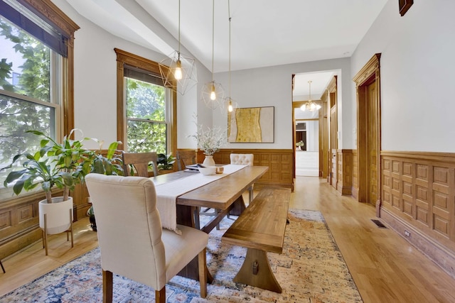 dining room with light hardwood / wood-style floors and an inviting chandelier