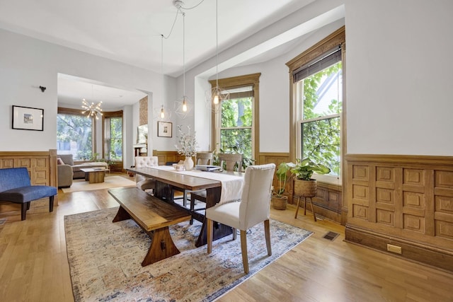 dining room with light hardwood / wood-style flooring and an inviting chandelier