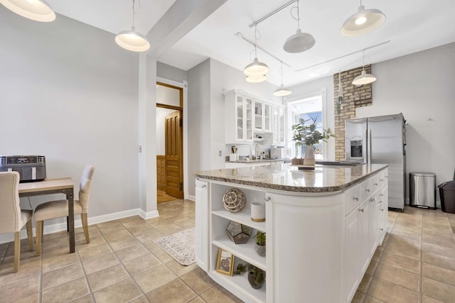 kitchen featuring white cabinetry, sink, hanging light fixtures, stainless steel fridge with ice dispenser, and dark stone counters