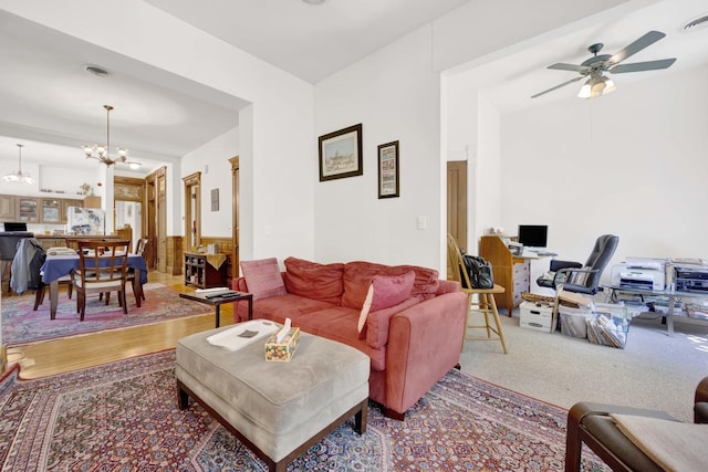 living room featuring ceiling fan with notable chandelier