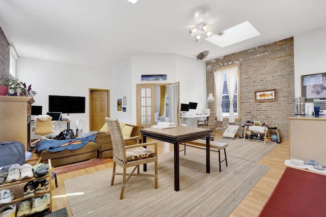 office space with a skylight, light hardwood / wood-style flooring, and brick wall