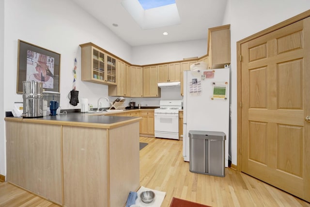 kitchen featuring kitchen peninsula, light brown cabinetry, light wood-type flooring, a skylight, and white appliances