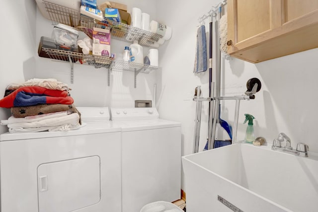 clothes washing area with cabinets, independent washer and dryer, and sink