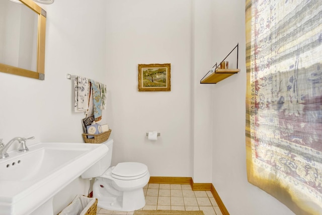 bathroom featuring toilet, tile patterned floors, and sink