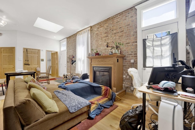 living room with hardwood / wood-style floors, plenty of natural light, and brick wall