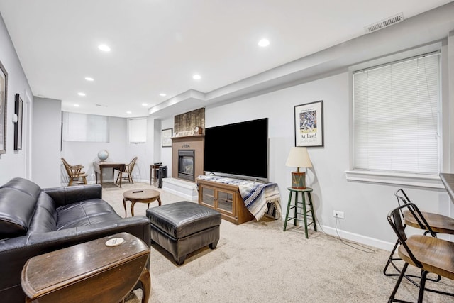 living room featuring a fireplace and light carpet