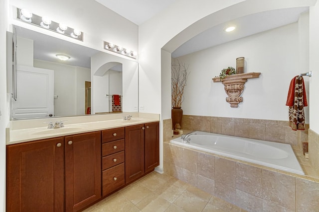 bathroom with vanity, tile patterned flooring, and a relaxing tiled tub