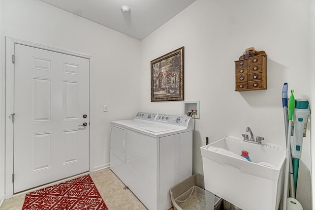 clothes washing area with washer and clothes dryer, light tile patterned floors, and sink