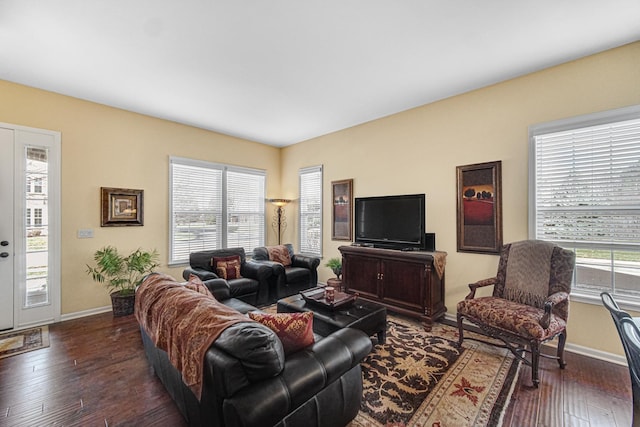 living room with dark hardwood / wood-style flooring and a healthy amount of sunlight