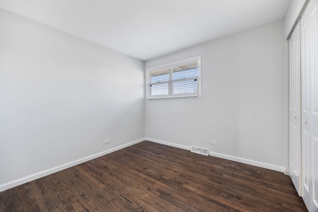 unfurnished bedroom featuring dark hardwood / wood-style flooring and a closet