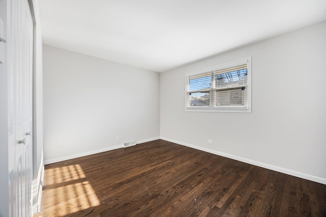 spare room with dark hardwood / wood-style flooring