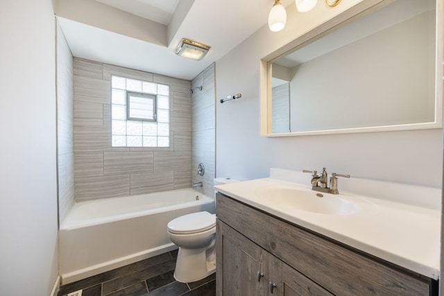 full bathroom featuring vanity, tiled shower / bath combo, and toilet