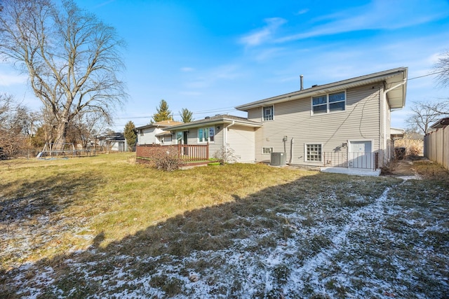 rear view of house with a yard, central air condition unit, and a wooden deck