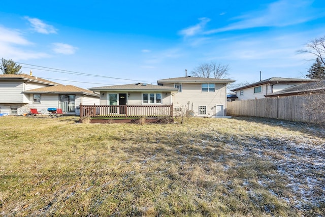 rear view of property featuring a deck and a lawn