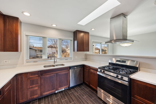 kitchen with sink, a skylight, island exhaust hood, and stainless steel appliances