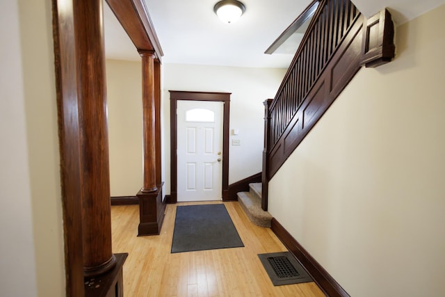 entryway with decorative columns and light hardwood / wood-style floors