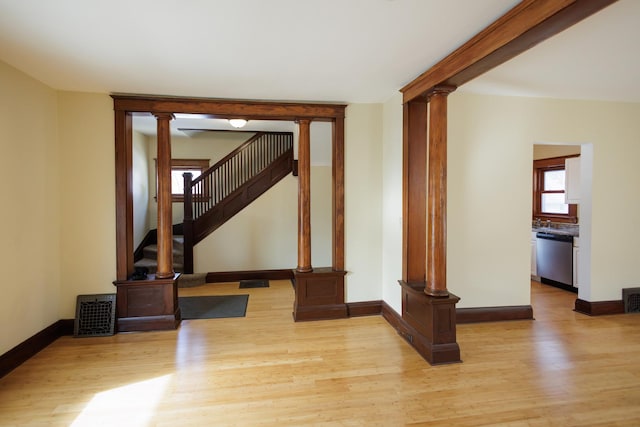 unfurnished living room with light hardwood / wood-style floors and ornate columns