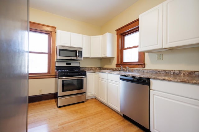 kitchen featuring white cabinets, stainless steel appliances, light hardwood / wood-style floors, and sink