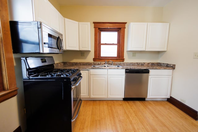 kitchen featuring sink, white cabinetry, appliances with stainless steel finishes, and light wood-type flooring