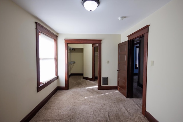 hallway featuring light colored carpet