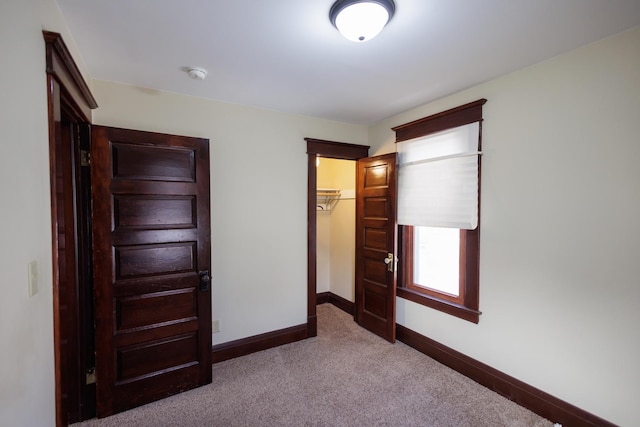 unfurnished bedroom with carpet floors, a closet, and a walk in closet