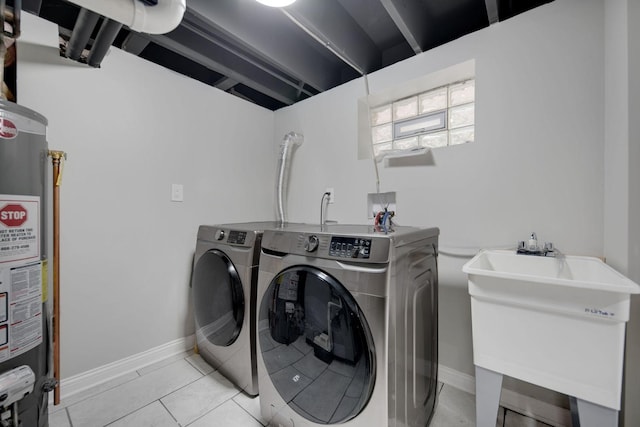 washroom with washing machine and clothes dryer, water heater, sink, and light tile patterned flooring