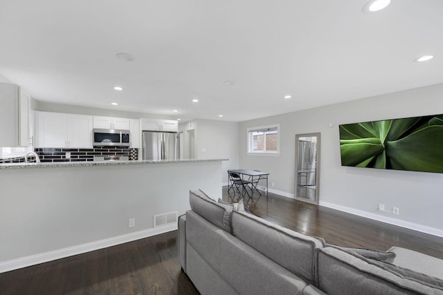 living room with dark hardwood / wood-style floors and sink