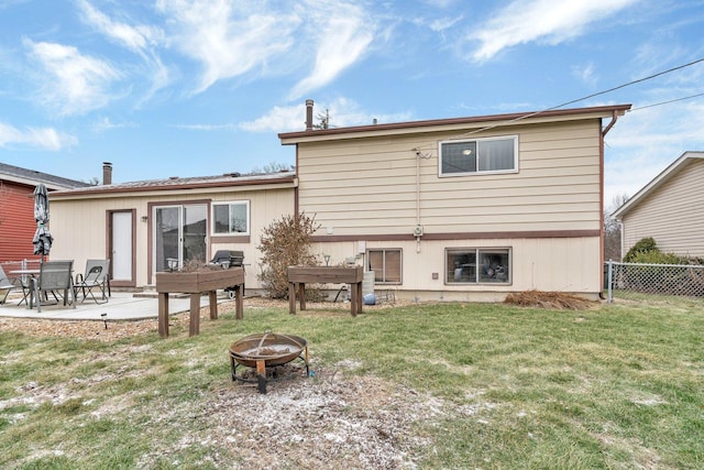 back of house with a lawn, a patio area, and an outdoor fire pit