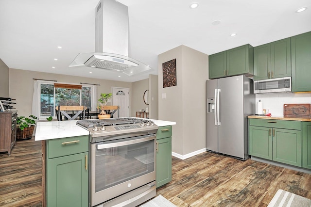 kitchen with green cabinets, island range hood, and appliances with stainless steel finishes