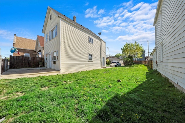 view of side of property with a yard and a patio area