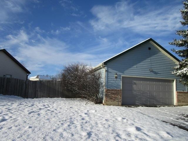 snow covered property with a garage