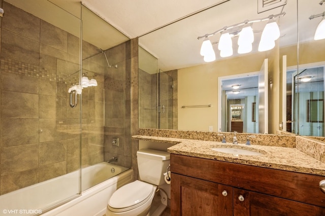 full bathroom featuring bath / shower combo with glass door, vanity, and toilet