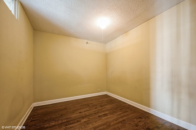 unfurnished room with dark hardwood / wood-style floors and a textured ceiling