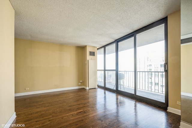 unfurnished room with dark hardwood / wood-style flooring, floor to ceiling windows, and a textured ceiling