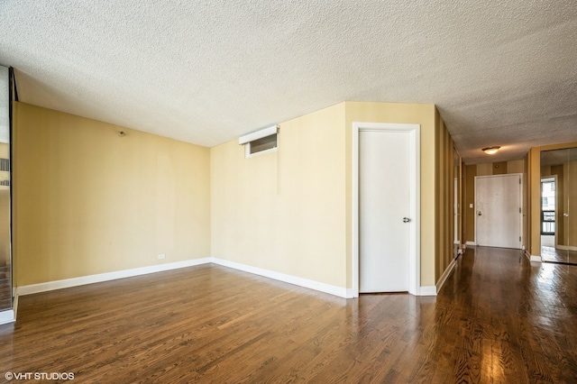 empty room featuring dark hardwood / wood-style floors and a textured ceiling