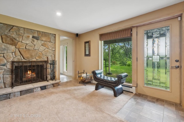 interior space featuring a fireplace, light colored carpet, and a baseboard radiator