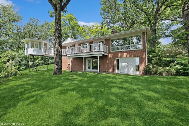 back of property featuring a deck and a lawn