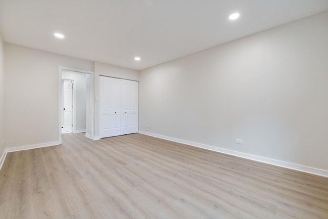 unfurnished bedroom with a closet and light hardwood / wood-style floors