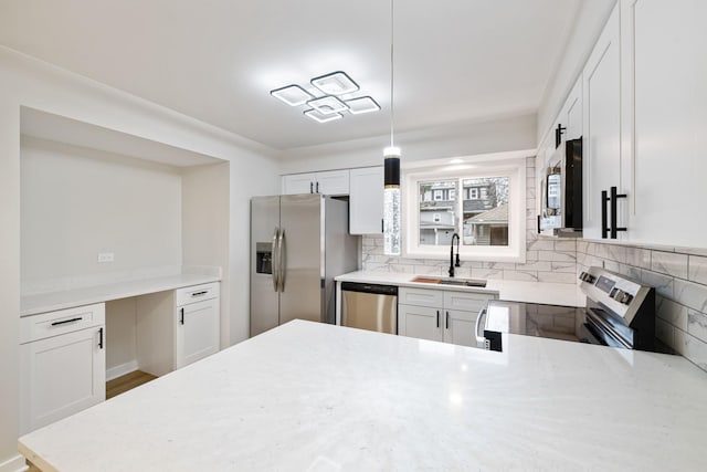 kitchen with hanging light fixtures, sink, white cabinets, and stainless steel appliances