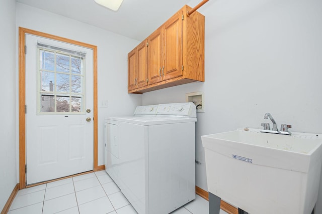 laundry area featuring separate washer and dryer, sink, light tile patterned floors, and cabinets