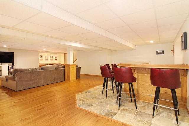 bar featuring a drop ceiling and wood-type flooring