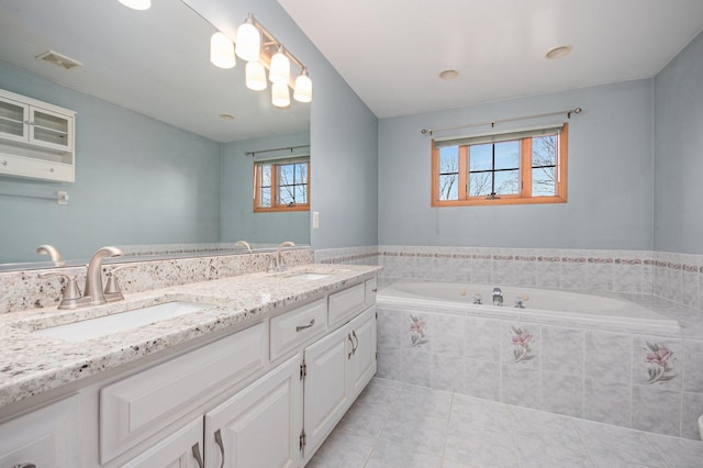 bathroom featuring vanity, tiled bath, tile patterned floors, and plenty of natural light