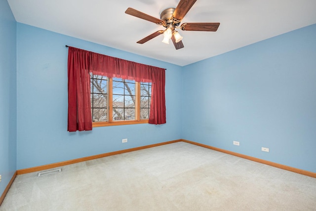 carpeted spare room featuring ceiling fan