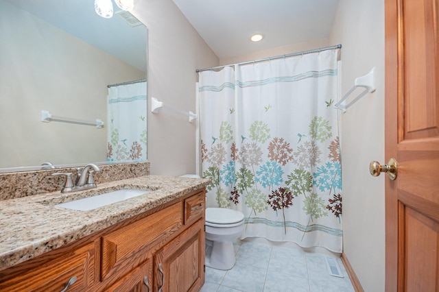 bathroom with toilet, vanity, and tile patterned floors